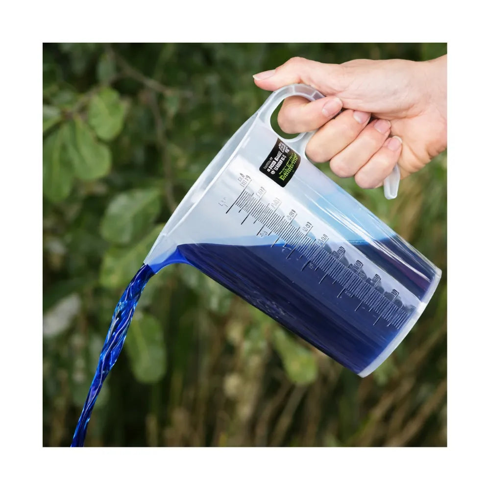 Hand pouring blue liquid from BAINBRIDGE chemical measuring jug with easy-grip handle and measurement markings