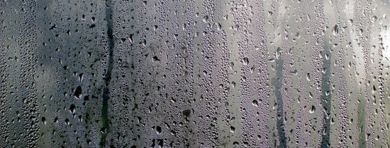 Heavy condensation and water droplets forming on a glass surface, illustrating high humidity and low VPD conditions in a grow room environment