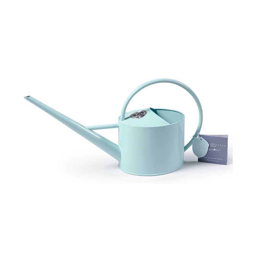 Soft blue Sophie Conran indoor watering can with long spout and ergonomic handle, featuring a metal logo seal and designer tag.